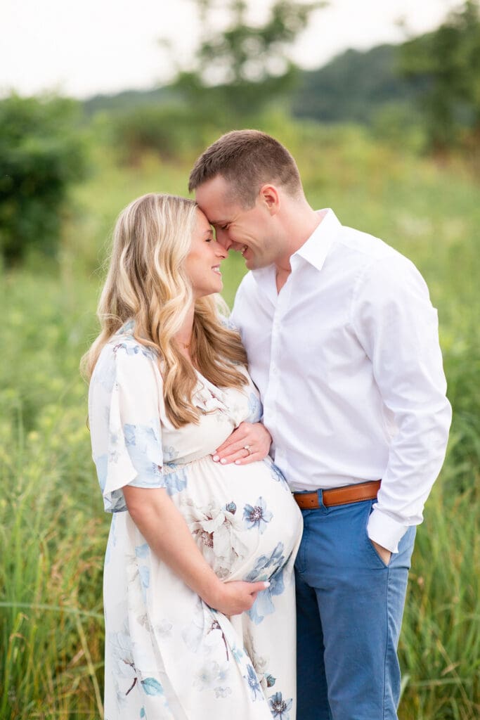 family maternity session Beckley Creek Park Louisville KY couple touching foreheads embracing on gravel path surrounded by lush greenery