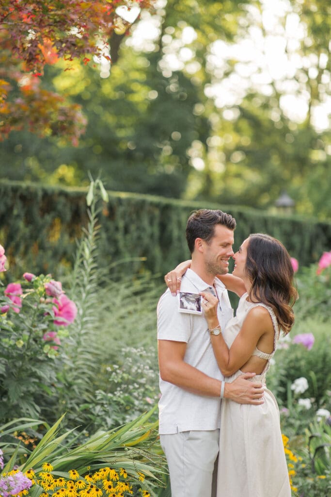 Louisville maternity photographer captures couple embracing among pink roses at Whitehall House and Gardens