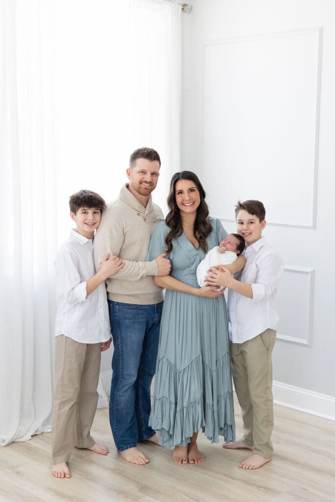 studio newborn photography Louisville KY family of five with mother father two older sons and newborn baby in white studio