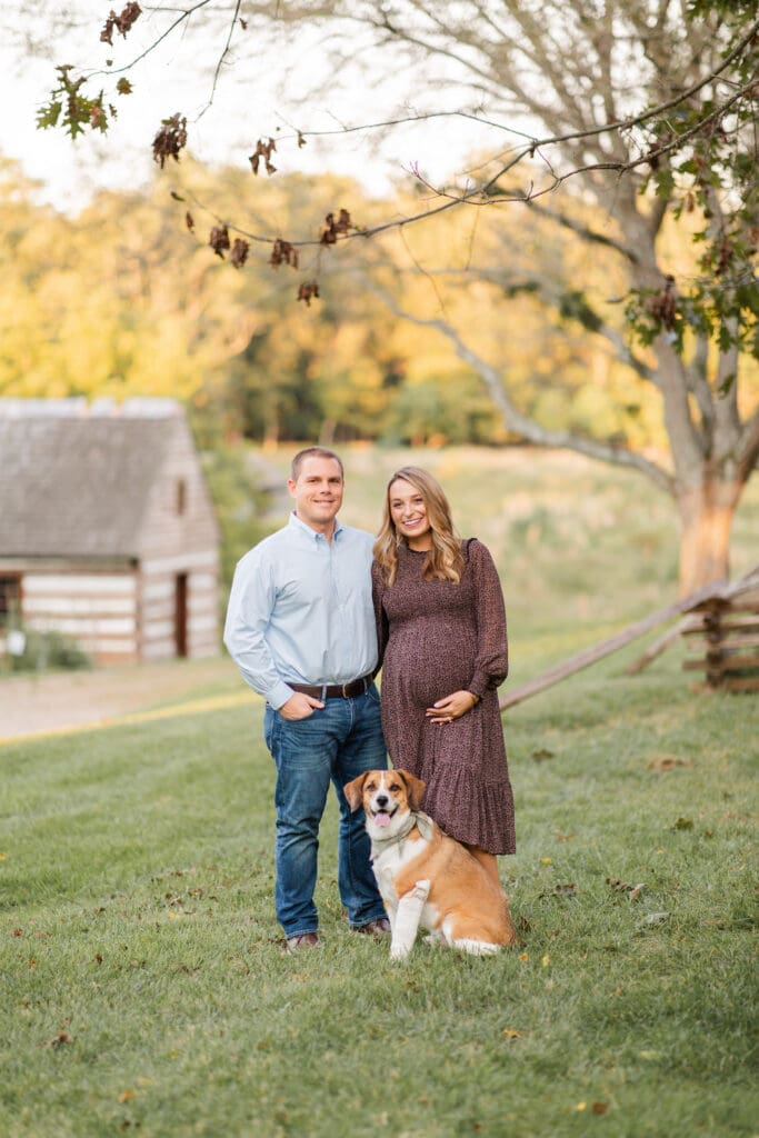 
family maternity photography Louisville KY couple with dog standing on lawn at Locust Grove during golden hour