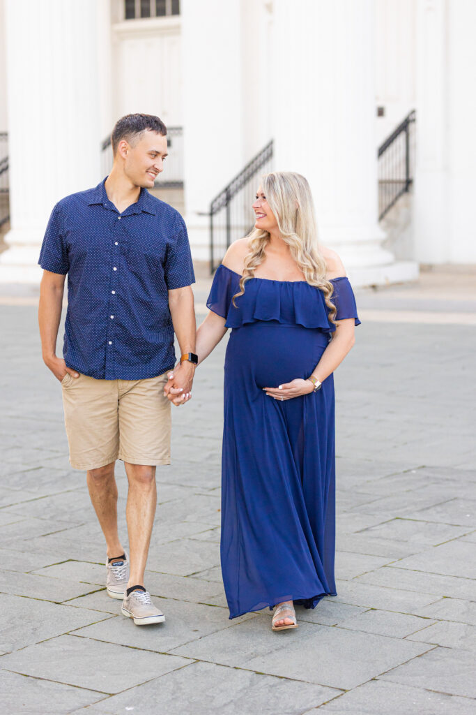 Louisville maternity photographer captures expectant couple walking hand in hand at the Louisville Water Tower