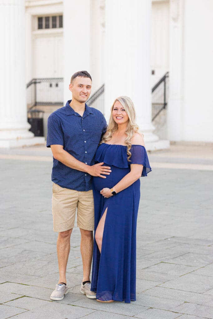 Maternity photographer in Louisville Kentucky captures couple embracing among the white columns of the Louisville Water Tower
