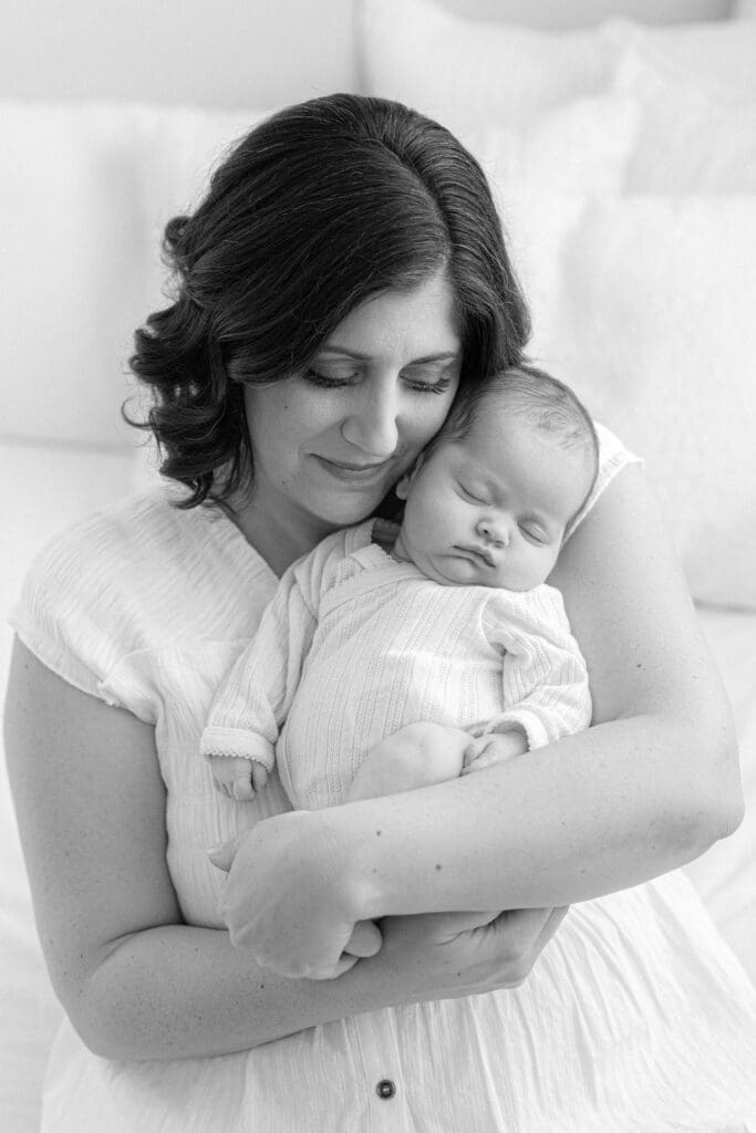 newborn photographer Louisville KY mother cradling sleeping newborn baby girl in white dress